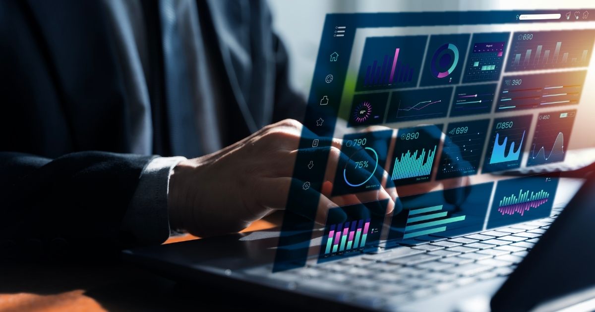 Close-up photo of a person in a dark suit working on a laptop, with translucent blue and teal data dashboards, charts, and KPI tiles overlaid on the screen. Used as the background visual for the DataPact 3.0 article on entrada.ai.